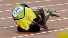 Jamaica's Usain Bolt falls on the track after suffering an injury in the men's 4x100-meter final during the World ...