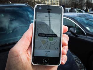 (FILES) This file photo taken on February 9, 2016 in Paris shows a smartphone displaying the app for ride service Uber with a box reading "No more drivers", as Uber suspends the app from 11am to 3pm in support of protesting non-licensed private hire cab drivers. Uber drivers in France express grievances against the US-based transport company Uber, such as degraded working conditions, low financial viability and the increasing risk of accidents. In an attempt to regulate the sector, a bill, already passed by the Parliament, will be examined in the French Senate on November 2, 2016. / AFP PHOTO / Geoffroy Van der Hasselt