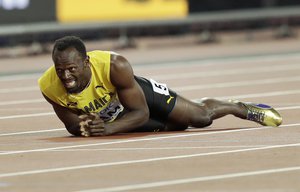 Jamaica's Usain Bolt lies on the track after he injured himself during the 4x100 m relay final during the World Athletics Championships in London Saturday, Aug. 12, 2017.