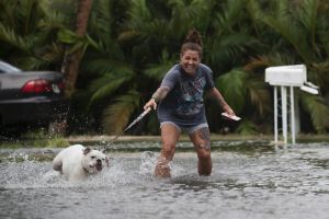Darcelle Jacobs and her dog Skittles check out the flooding on their street in Fort Myers Beach, Fla., Monday, July 31, ...