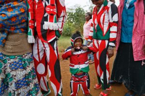 Joseph Njoroge Kimani, 3, makes a face for the camera as he stands with his father James Kimani Njoroge, center-left, ...