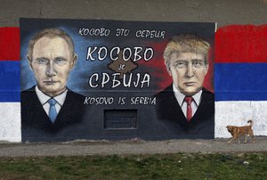 A dog passes by graffiti depicting the Russian President Vladimir Putin, left, and US President Elect Donald Trump in a suburb of Belgrade, Serbia, Tuesday, Dec. 6, 2016. The Cyrillic letters on graffiti read "Kosovo is Serbia", as Serbia doesn't recognise Kosovo's independence.