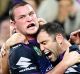 Storm's Joe Stimson is hugged by captain Cameron Smith after his match-winning try against the Roosters.