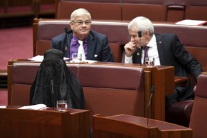 Sen. Pauline Hanson, bottom left, wears a burqa during question time in the Senate chamber at Parliament House in Canberra, Australia, Thursday, Aug. 17, 2017.