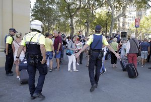 Police officers tell members of the public to leave the scene in a street in Barcelona, Spain, Thursday, Aug. 17, 2017.