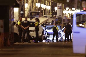 Police officers stand next to the van involved on an attack in Las Ramblas in Barcelona, Spain, Thursday, Aug. 17, 2017.