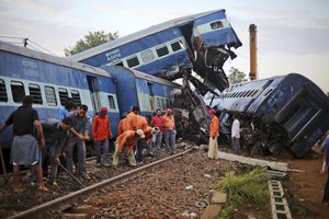 Workers repair the track near the upturned coaches of the Kalinga-Utkal Express after an accident near Khatauli, in the northern Indian state of Uttar Pradesh, India, Sunday, Aug. 20, 2017.