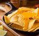 A plate of delicious plain nacho corn chips with cheese sauce.