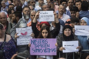 A girl holds a banner that reads: "We are also Victims" during a protest by the Muslim community condemning the attack in Barcelona, Spain, Monday Aug. 21, 2017.