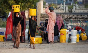 In this Tuesday, Aug. 22, 2017 photo, people fetch water for their families at a tube well in Rawalpindi, Pakistan,  A new study suggests some 50 million people living across Pakistan's Indus Valley are at risk of arsenic poisoning from tainted groundwater. A Pakistani government research official acknowledged Wednesday that arsenic levels were rising, blaming the