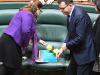 Victorian Premier Daniel Andrews places a small box next to yellow flowers on the seat of Victorian MP Fiona Richardson in Parliament House in Melbourne, Thursday, August 24, 2017. Victoria's Minister for Women Fiona Richardson has died a day after revealing her renewed battle with cancer. The 50-year-old, who was also Australia's first minister for the prevention of family violence, only announced on Tuesday that she had been diagnosed with multiple tumours. (AAP Image/Joe Castro) NO ARCHIVING