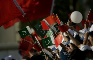 Pakistani and Chinese people wave national flags during the Olympic torch ceremony in Islamabad, Pakistan, Wednesday, April 16, 2008