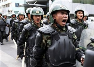 Chinese paramilitary police patrol in Urumqi, western China's Xinjiang province, Wednesday, July 8, 2009. China flooded the capital of western Xinjiang province with security forces Wednesday after ethnic riots left at least 156 dead.