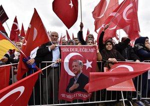 Turkish people protest with a picture of president Erdogan during a demonstration against the Turkey coup attempt in support of Turkey's president Erdogan in Cologne, Germany, Sunday, July 31, 2016.