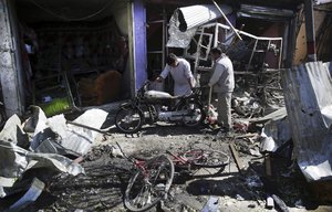 In this Monday, July 24, 2017 file photo, Men look at the remains of their properties at the site of a suicide attack in Kabul, Afghanistan. In the last week the Taliban have overrun two districts in the north and west of Kabul, temporarily cut a key highway linking the capital to the north and staged a suicide bombing in the heart of the capital Kabul.