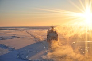 NOME, Alaska  The Coast Guard Cutter Healy breaks ice as the sun begins to set in the Nome harbor Jan. 13, 2012.  The Healy and crew have been deployed for approximately eight months to support Arctic science research and also escorting and breaking ice for the Russian tanker Renda.  U.S. Coast Guard photo by Petty Officer 2nd Class Charly Hengen. (1497620) ( Healy, Renda overflight )