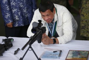 Philippine President Rodrigo Duterte checks a Chinese-made CS/LR4A Sniper's Rifle during the ceremonial turnover of thousands of brand-new rifles and more than six million ammunitions by China to the Philippines Wednesday, June 28, 2017 at Clark Airbase in northern Philippines.