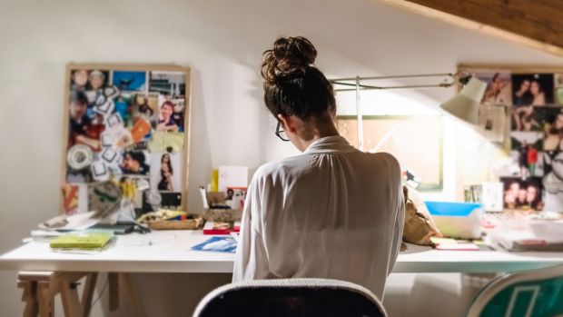 Young businesswoman at her desk in home studio.