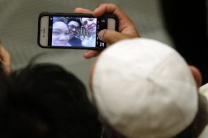 Pope Francis poses for a selfie with a couple attending his weekly general audience, at the Vatican, Wednesday, Aug. 23, ...