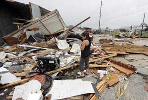 Jennifer Bryant looks over the debris from her family business destroyed by Hurricane Harvey Saturday, Aug. 26, 2017, in Katy, Texas.