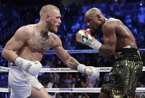 Floyd Mayweather Jr., right, fights Conor McGregor in a super welterweight boxing match Saturday, Aug. 26, 2017, in Las Vegas.