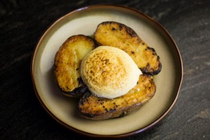 Royal blue potatoes topped with a cloud of mustard foam.