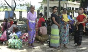 In this image made from video, residents displaced by violence wait in Buthidaung township, Sunday, Aug. 27, 2017, in Rakhine State, Myanmar.