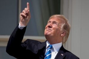 President Donald Trump points to the sun, unprotected, during the solar eclipse.