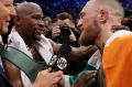 Floyd Mayweather Jr., left, speaks with Conor McGregor after a super welterweight boxing match Saturday, Aug. 26, 2017, ...