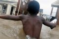 Jayveon Murphy, 10, makes is way through floodwaters from  Harvey to check on a neighbour at his apartment complex in ...