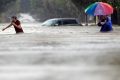 Moses Juarez and Anselmo Padilla wade through floodwaters Houston, Texas on Sunday.