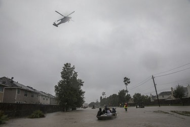 A military helicopter flies overhead as residents are evacuated from their neighborhood on the outskirts of Houston, Aug. 28, 2017.