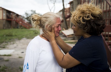 Genice Gipson comforts her lifelong friend, Loretta Capistran, outside of Capistran's apartment complex in Refugio, Texas, on Monday. "We got to be strong, baby," Gipson told Capistran.