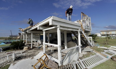 Joe Tijerina, right, works to salvage items from his home that was destroyed in the wake of Hurricane Harvey, Tuesday, Aug. 29, 2017, in Rockport, Texas.