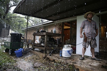 Wyatt Sebesta, 34, carries a revolver as he finishes moving most of the contents of his home to higher ground as the Brazos River surges nearby on Aug. 28, 2017 in Richmond, Texas.