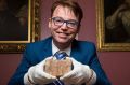 Daniel Mansfield holds the 3700-year-old Babylonian tablet that he and colleagues used to make their case.