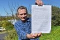 Alan Rowe holding a handwritten letter from the priest he accuses of abusing him in the 1970s that asks for forgiveness. 