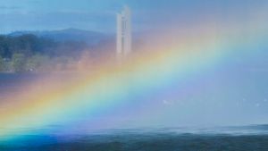 A walker passes a rainbow in the Captain Cook Jet on Thursday afternoon.