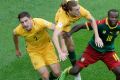 Australia's Jackson Irvine falls between teammate Milos Degenek, left, and Cameroon's Vincent Aboubakar during the ...