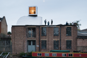 Tiny house on top of a warehouse designed to look like air duct