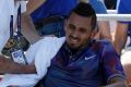 Trainer Paul Ness works on Kyrgios, during a break in play.