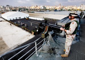 US Navy Petty Officer Charles Agent with downtown Beirut skyline seen in the horizon guards US Navy HSV 2 Swift high speed boat as sailors unload humanitarian supplies at the capital port of Beirut, Lebanon, Saturday, July 29, 2006.