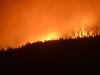 In an Aug. 30, 2017 photo, the Rice Ridge Fire burns in the Lolo National Forest near Woodworth Road northeast of Salmon Lake, Mont. The lingering wildfire season and endless smoke has affected the western Montana town of Seeley Lake to such a degree that Missoula County health officials urged people to leave to escape the pollution weeks before Tuesdayâ€™s order to evacuate part of the town due to the encroaching fire. (Rion Sanders/The Great Falls Tribune via AP)