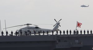 Members of the Japan Maritime Self-Defense Force stand on deck of the latest destroyer "Izumo" during an event held ahead of Sunday's official triennial naval fleet review off Sagami Bay, south of Tokyo, Thursday, Oct. 15, 2015.