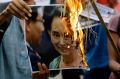 Reputation going up in flames: activists burn a poster of Aung San Suu Kyi.