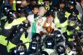 Residents and members of civic and religious groups battle riot police trying to break up their protest against the ...