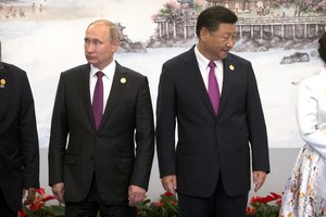 Russian President Vladimir Putin, left, and Chinese President Xi Jinping line up for a family photo during the BRICS Summit in southeastern China's Fujian Province, Monday, Sept. 4, 2017.