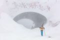 Snow drifting around the tunnel at Hotham as people hike up the closed road to ski.