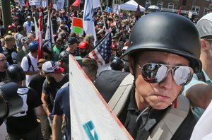 An Alt Right demonstrator with a helmet and shield walks into Lee Park in Charlottesville, Va., Saturday, Aug. 12, 2017.