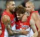 Gary Rohan (centre) of the Swans celebrates with Lance Franklin.